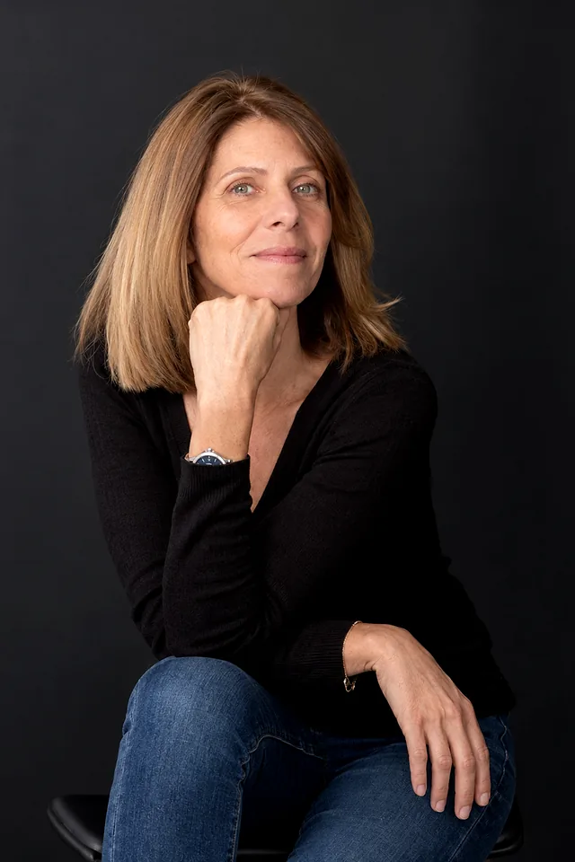 Portrait de Frédérique Aldebert, courtière en crédit immobilier au Touvet, assise, le menton posé sur la main.